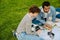 Two multinational students doing homework together while sitting in park