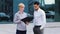 Two multiracial colleagues caucasian business woman salesperson consultant holding folder with documents showing plan