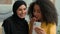 Two multiracial happy business women African American girl Arabian muslim islamic in hijab female students bloggers