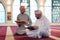 two muslim people in mosque reading quran together concept of islamic education