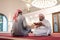 two muslim people in mosque reading quran together concept of islamic education