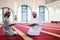 two muslim people in mosque reading quran together concept of islamic education