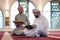 two muslim people in mosque reading quran together concept of islamic education