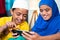 Two muslim sibling kids busy using mobile at home - concept of kids using technology, internet and social media