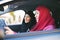 Two muslim women inside a car - mother and daughter traveling together