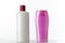 Two nameless plastic bottles white and pink from under a cosmetic product on a white background