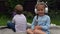 Two naughty Siblings dont share. boy ans girl listening to music on headphones outside. Children and technology. Brother