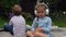 Two naughty Siblings dont share. boy ans girl listening to music on headphones outside. Children and technology. Brother