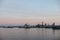 Two naval harbor tugs against the background of warships in the Petrovskaya pier of Kronstadt. Evening sunset. Russia