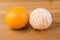Two navel oranges one peeled one unpeeled