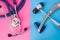 Two neurological rubber reflex hummers and medical stethoscope is in two colors background: blue and pink. Concept of neurological