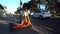 Two Neuron orange rent to ride electric scooters e-scooters parked beside on a pavement beside a road and pedestrian crossing