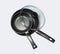 Two new empty frying pans with a lid, top view, on a white background.