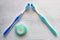 Two new toothbrushes  and container of dental floss. Dental floss laid out in the shape of a tooth. Tools for personal oral hygien