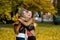 Two nice girls joyfully embrace in the autumn park.