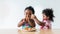 Two Nigerian baby girls, aged 2 and 1, eating pizza and the sister is looking at the pizza in her sister\'s hand