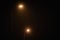 Two night lamppost shines with faint mysterious yellow light through evening fog at quiet night