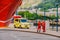 Two Norwegian paramedics in red uniforms are resting near an ambulance parked in a port near a large ship. Theme healthcare and