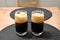 Two not full glasses of black beer on the table photography