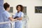 Two Nurses Meeting In Hospital Holding Digital Tablet