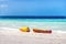 Two ocean kayaks on the beach with white sand and blue ocean