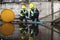 Two Officers of Environmental Engineering Wearing Protective Equipment with Gas Masks Inspected Oil Spill Contamination in