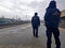 Two officers of the railway guard in the uniform are standing on a perron at the station in cold, cloudy weather. Transport commun