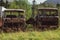 Two old broken and  rusted trucks on the field