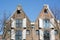 Two old classical holland houses with shutters on the street in the day