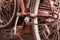 Two old dusty bicycles standing in closet under the stairs. Close up wheel, spokes, transmission chain and pedals.