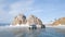 Two old excursion cars on the background of Shamanka rock near Olkhon island. Cars are on the ice of the frozen lake Baikal