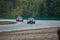 Two old fast sports car driving on a racing circuit.