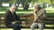 Two old friends sitting on bench in park and remembering young years, memories