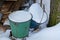 Two old metal buckets with white snow on a tree street