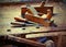 two old planes and two chisels over the work table with the wood