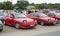 Two old red Mazda 323F cars at a car show