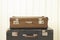 Two old retro suitcases White wooden background Vintage tinting