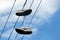 Two old sneakers hang on electric wires. The concept is time for a vacation