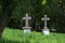 Two old stone crosses as tombstones in an overgrown cemetery