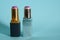 Two old used tubes of lipstick stand on a blue background.