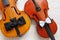 Two  Old violins and two bow ties on the white wooden background. Top view, close-up