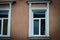 two old windows on a brown building with a matryoshka