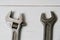 Two old wrenches, adjustable spanner and spanners, on light wooden background with copy space