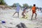 Two older boys throwing sand at younger one