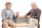 Two older men playing cards seated on a bench