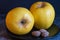 Two opal apples and three chocolate-covered almonds on a black plate