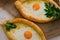 Two open pie with egg yolk and parsley on sackcloth.