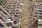 Two opposing rows of suspended empty deck chairs in rows lined up in order on the beach in the sand