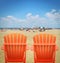 Two Orange Beach Chairs in Sand
