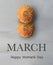 Two orange Dhalia flowers and `March. Happy Women`s day` text in English